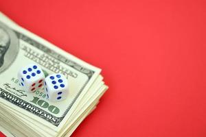 Money, finance and gambling concept. Close up on an American hundred US dollar banknotes and two white dice on top showing the numbers six photo