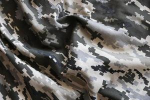 Fabric with texture of Ukrainian military pixeled camouflage. Cloth with camo pattern in grey, brown and green pixel shapes. Official uniform of Ukrainian soldiers photo