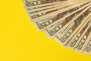 Big amount of old twenty dollar bills on yellow background. Money earnings, payday or tax paying period photo