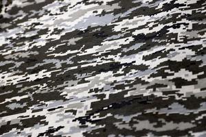 Fabric with texture of Ukrainian military pixeled camouflage. Cloth with camo pattern in grey, brown and green pixel shapes. Official uniform of Ukrainian soldiers photo