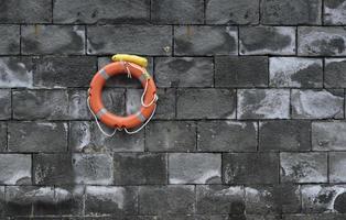 Lifesaver on a stone wall at the harbor photo