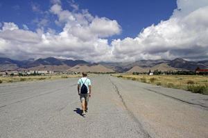 Man seen from the back as he walks on an abandoned airfield photo