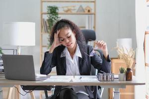 Serious african american businesswoman sitting at table looking at laptop screen. Ethnic woman read message email with important news, business documents online, chatting with clients working remotely photo