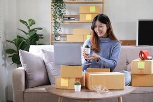 Starting Small business entrepreneur freelance, Portrait young woman working at home office, BOX, smartphone, laptop, online, marketing, packaging, delivery, b2b, SME, e-commerce concept photo