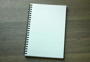 blank spiral notebook on dark wood background photo