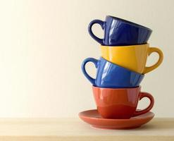 pila de coloridas tazas de café en la mesa foto