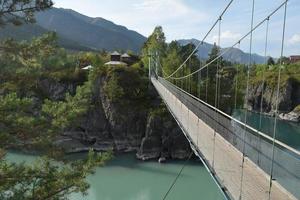 suspension bridge over the mountain river photo