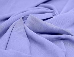 Linen, cotton pleated. Abstract textile background. The color of 2022 is Very Peri. Concept, sewing, tailor shop. photo