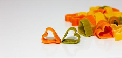 colored pasta in the shape of a heart on a light background. Healthy food concept. Soft focus photo