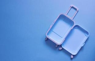 Fully opened blue suitcase, on a blue background, top view. Vacation, travel concept. copy space photo