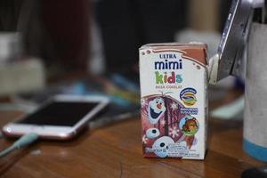 On the work table there is a box of ULTRA MIMI KIDS fresh milk that children love photo