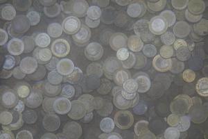 coins tossed into the wishing pond photo