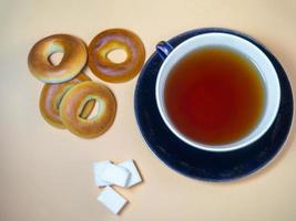 A cup of black tea with sugar cubes and sushki. photo