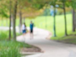 A defocused image of a couple walking on a winding path in the park. photo