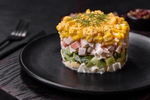 Fresh vegetable salad with corn, pepper, crab, cucumber, eggs and mayonnaise photo