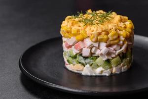 Fresh vegetable salad with corn, pepper, crab, cucumber, eggs and mayonnaise photo