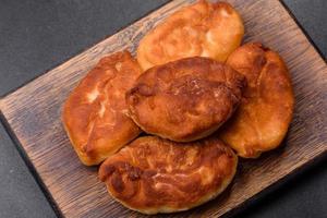 Cooking pies with potato on a wooden cutting board photo