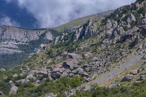 Mountain landscape, rocks with collapsed huge boulders against a sky with clouds. photo