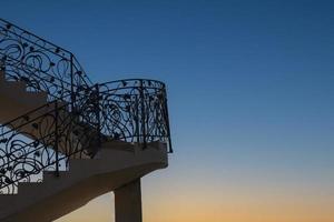 Staircase with metal railing outdoors at dawn. Concept way to the sky. photo