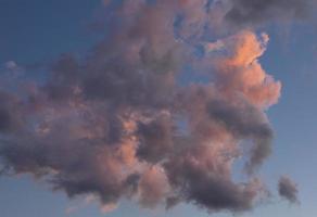 Cloud landscape. Pink and brown summer cumulus clouds on a blue sky during sunset. Wallpaper. Background. photo