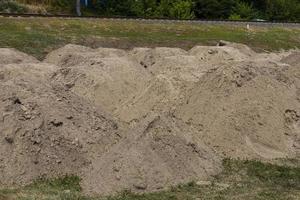 Construction sand. Mountain of sand on construction site. Excavated earth. Preparation of foundation for road. photo