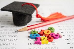 número de matemáticas colorido con sombrero de graduación y lápiz en el fondo de la hoja de respuestas, estudio de educación concepto de enseñanza de aprendizaje de matemáticas. foto