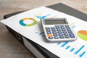 Magnifying glass and calculator on charts graphs paper. Financial development, Banking Account, Statistics, Investment Analytic research data economy, Stock exchange trading, Business office concept. photo