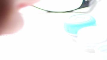 mãos masculinas mudando de óculos para lentes de contato com cuidado higiênico tirando-os da caixa para corrigir a visão da visão como miopia ou hipermetropia por óculos de optometria para visão clara video