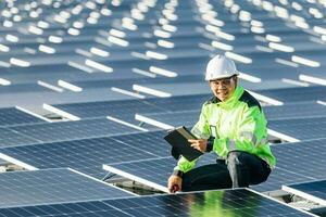 Successful young engineer in uniform  checks the productivity solar panel field for examination photo