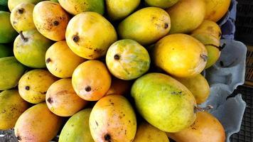 Heap of fresh ripe mangoes at market for sell photo