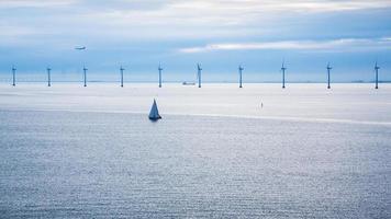 avión y barcos cerca del parque eólico marino foto