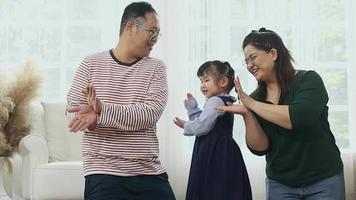 Happy asian family at home on vacation parents are teaching their daughters to sing. happy dance video