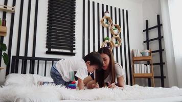 Asian mother and son play happily exchange birthday gift boxes in bed The love and bond between mother and child