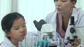 Aziatisch schoolmeisjes zijn aan het studeren wetenschap en technologie in een laboratorium. leraren onderwijzen wetenschap naar studenten voor aan het leren werkwijze vaardigheden. video