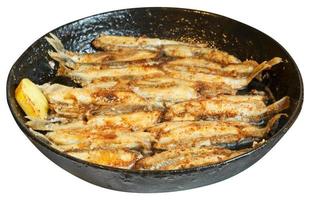 fried fish capelin on black frying pan isolated photo