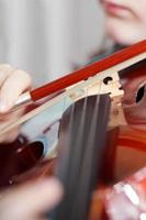 child plays on fiddle by bow photo