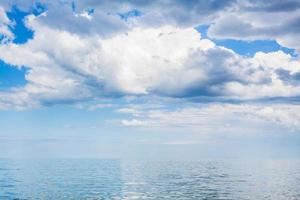 clouds in blue sky over calm water of Azov Sea photo