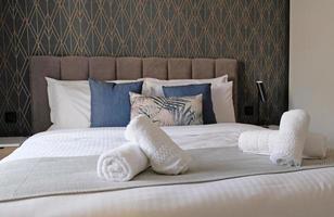 Hotel bedroom after room service is ready for customers, Bed with towels. The concept of modern interior design of a bedroom in a house or hotel where people sleep photo