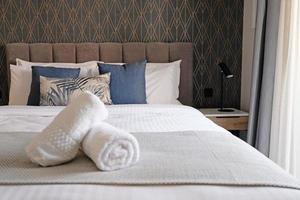 Hotel bedroom after room service is ready for customers, Bed with towels. The concept of modern interior design of a bedroom in a house or hotel where people sleep photo