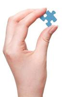 female arm holding blue puzzle piece photo