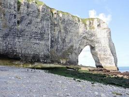 cliff with arch on pebble beach of Etretat photo