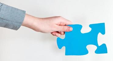 blue puzzle piece in female hand photo