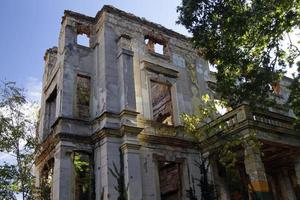 Remains of the war in Mostar, Bosnia and Herzegovina - Ruin without a roof with trees growing inside of it photo