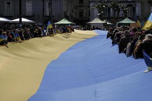 Naples, Italy, 2022 - A large crowd gathers waving the Ukrainian flag to protest the war and Russian aggression. photo