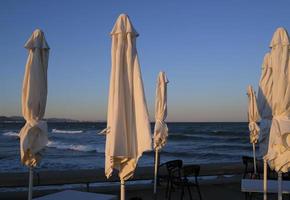 sombrillas cerradas en un bar de playa en valencia en invierno foto