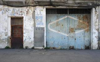 Weathered door to a garage of an abandoned building in Valencia Spain photo