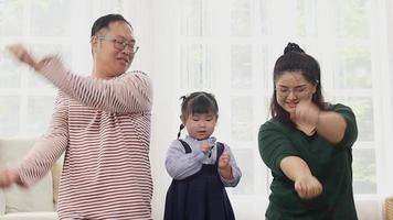 contento asiatico famiglia a casa su vacanza genitori siamo insegnamento loro figlie per cantare. contento danza video