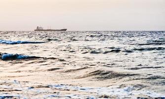 buque de carga seca en el mar rojo en puesta de sol rosa foto