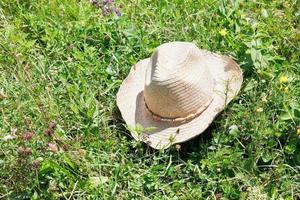 sombrero de vaquero de paja sobre hierba verde foto