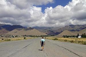 Man seen from the back as he walks on an abandoned airfield photo